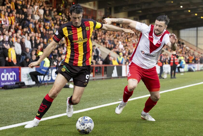 Partick Thistle striker Brian Graham holds off the challenge of Airdrie defender Callum Fordyce.