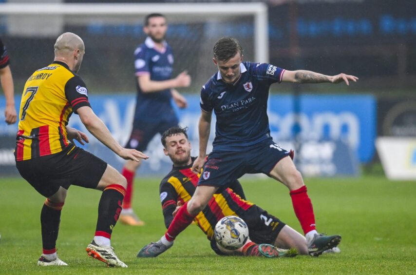 Raith Rovers midfielder Kyle Turner shields the ball from Partick Thistle duo Jack McMillan and Kerr McInroy.