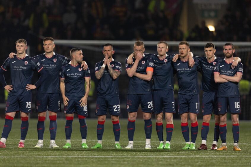 The Raith Rovers players stand in a line in the centre circle during their penalty shoot-out.