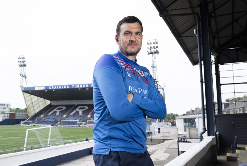 Raith Rovers Manager Ian Murray leans with his arms folded in the Stark's Park main stand.