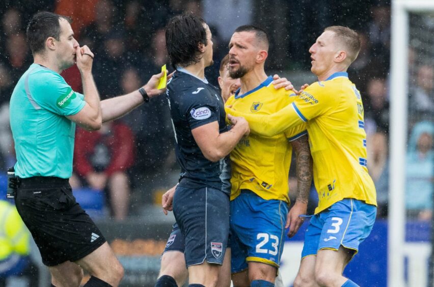 Raith Rovers defender Dylan Easton and Ross County's James Brown square up to each other.