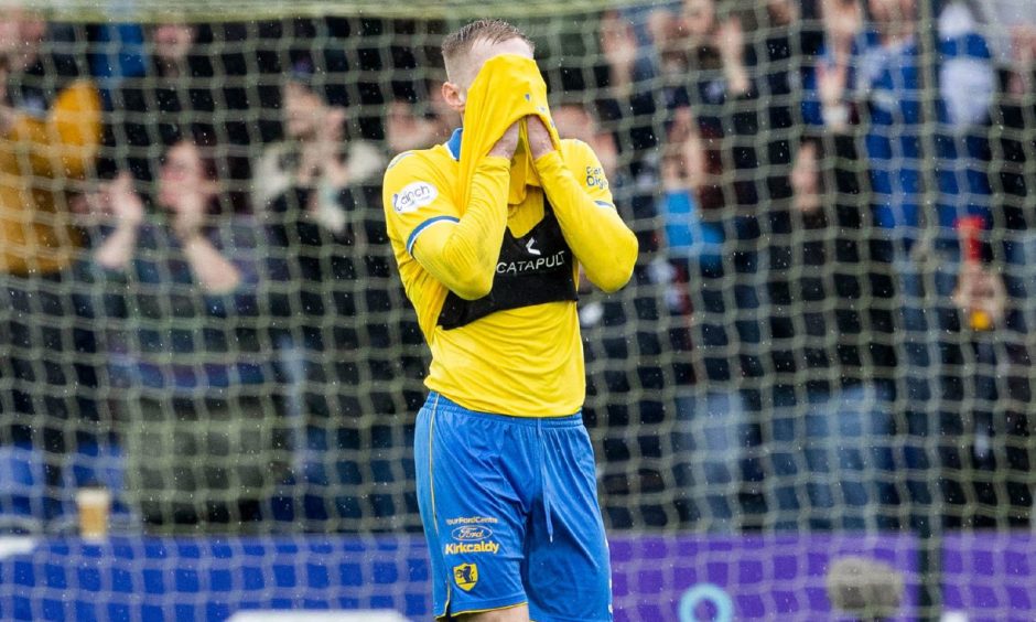 Raith Rovers defender Liam Dick hides his face in his shirt.