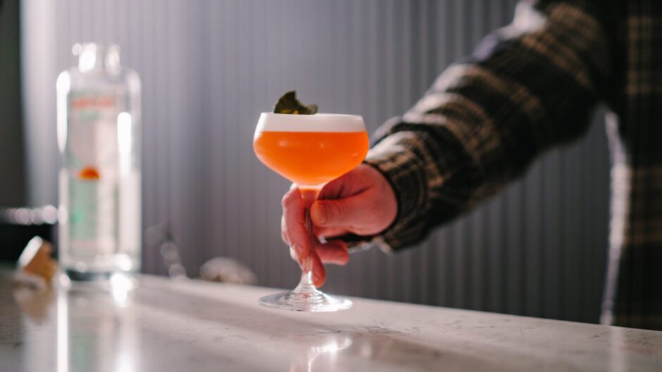 A barman serving a cocktail.