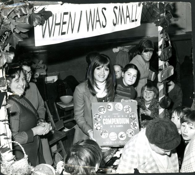 Surrounded by parents and children, Eve serves at one of the stalls at the Coupar Angus event in November 1973