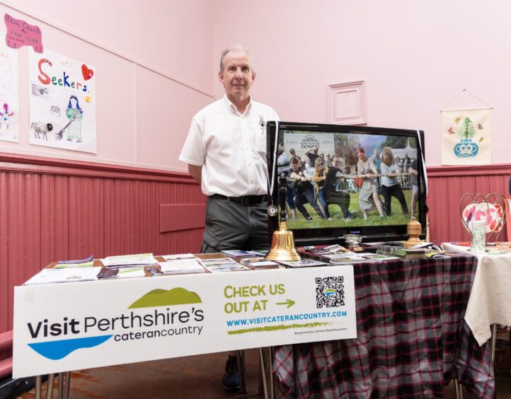 Man standing behind stall with Visit Perthshire banner