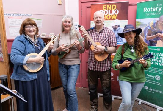 Four people playing ukuleles and banjos at Blairgowrie community event