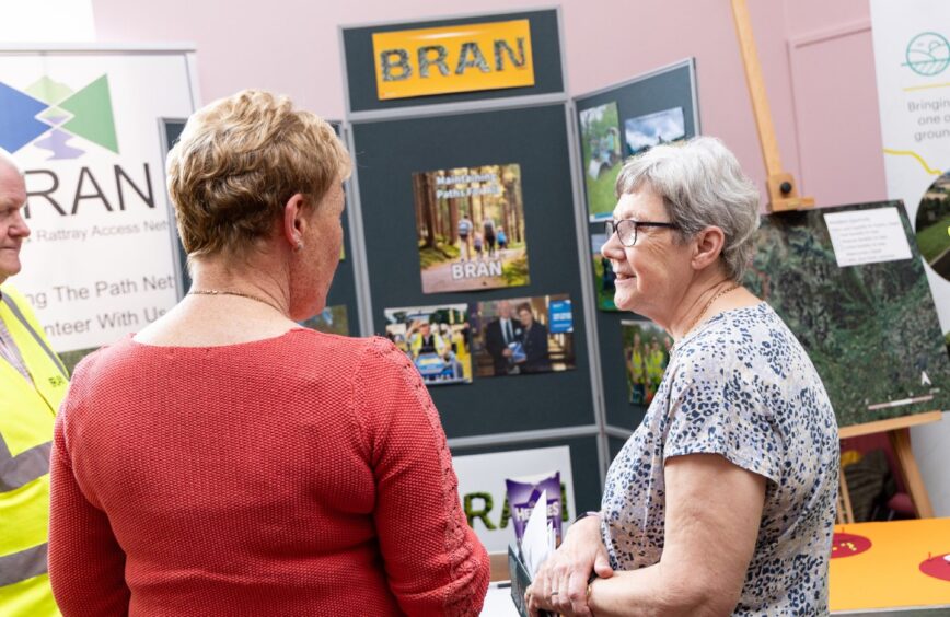 Two women talking next to BRAN info boards