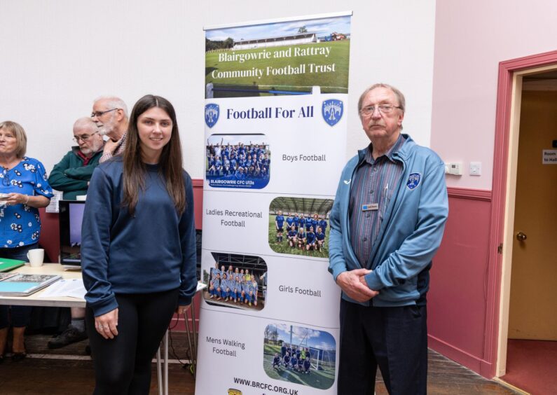 Young woman and man next to banner for Blairgowrie and Rattray Community Football Trust 