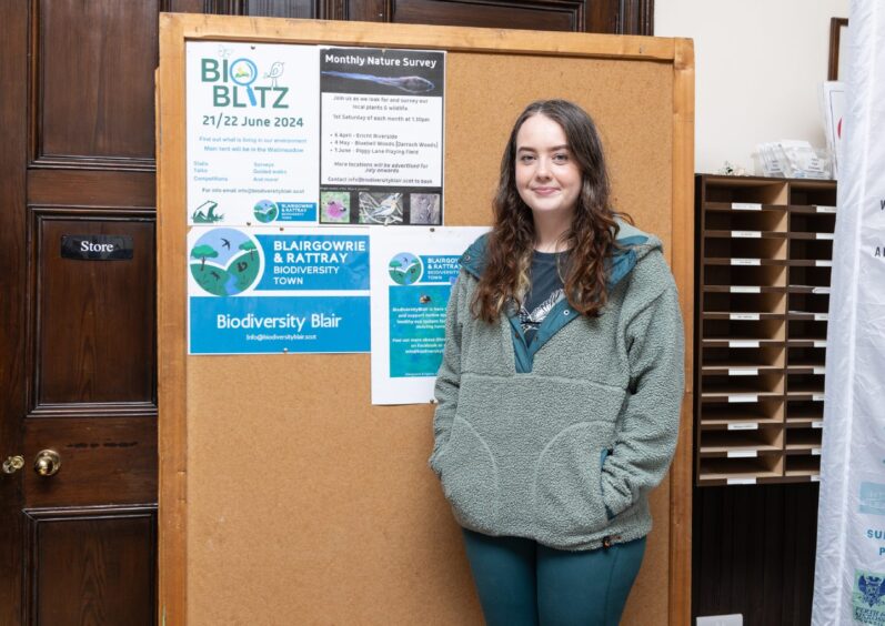 Young woman next to stall with BioBlitz leaflets