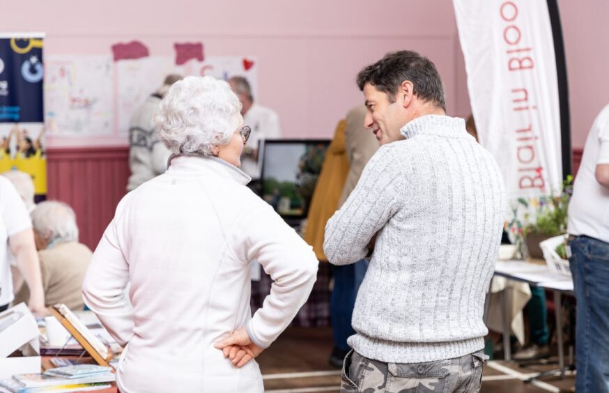 Grey haired woman and younger man talking