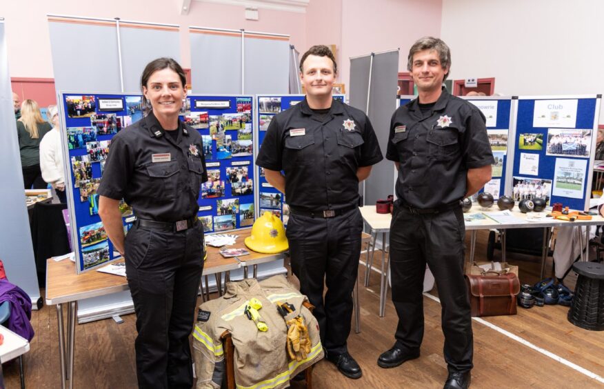 Tree firefighters standing next to stall at Blairgowrie event