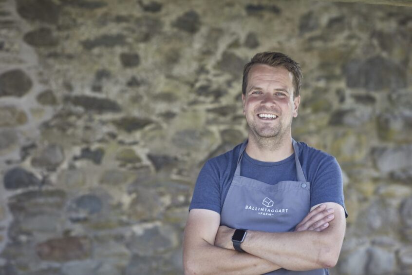 Chris Rowley smiling, arms folded, in Ballintaggart apron