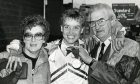 Liz celebrates with her parents, with her dad holding up her medal, after success in Edinburgh in 1986.