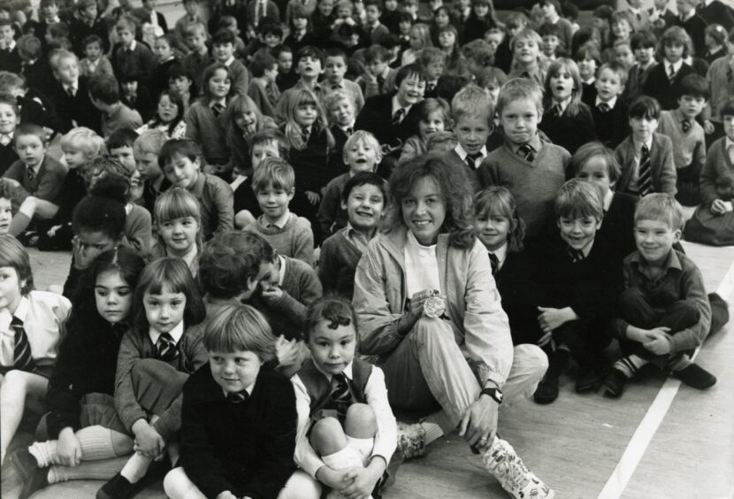 Pupils surround her as Liz McColgan visits her old school Whitfield Primary with her medal in 1988. 