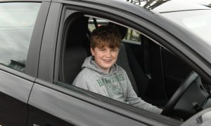 Alex in the drivers seat of of a Vauxhall Corsa about to start his driving lesson for kids in Fife.