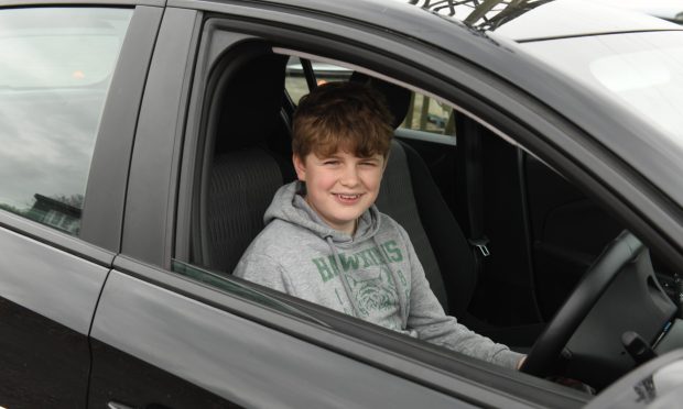 Alex in the drivers seat of of a Vauxhall Corsa about to start his driving lesson for kids in Fife.