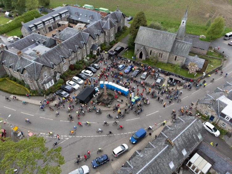 Aerial shot showing large group of cyclists in town square