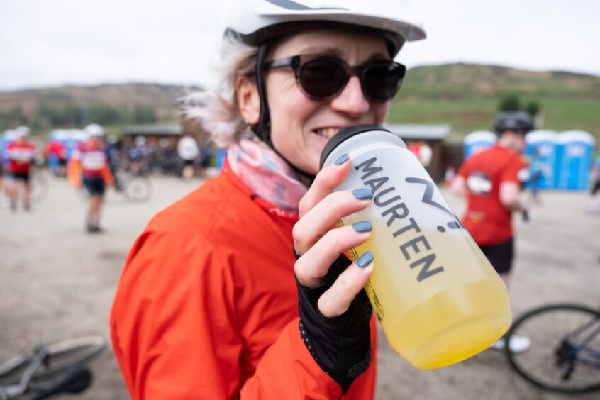 Woman cyclist drinking from water bottle