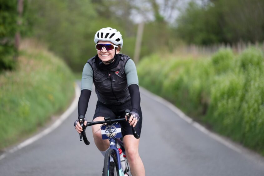 Woman cyclist on country road with no other cyclists around