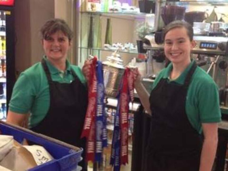 Gillian and Kiera Hamilton holding Scottish Cup behind counter at the Auchterarder Fish and Chip company