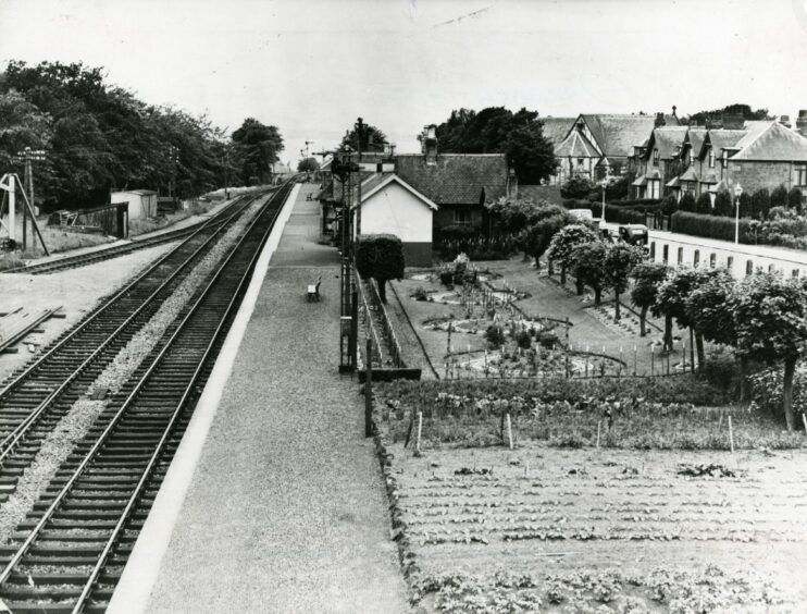 Barnhill station in 1950, with railway tracks on the left and buildings and grass on the right