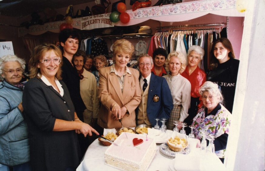 People gather around as a cake is cut to mark the Chest, Heart and Stroke Foundation shop's first birthday in September 1996.