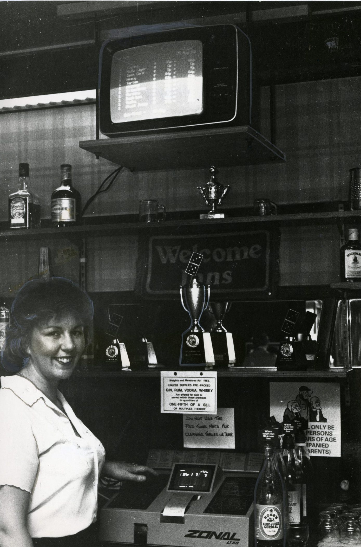 Margaret Hibbert stands beside the till in the  Admiral Bar.