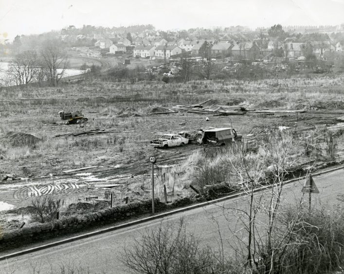 Old vehicles piling up in a field in February 1978.