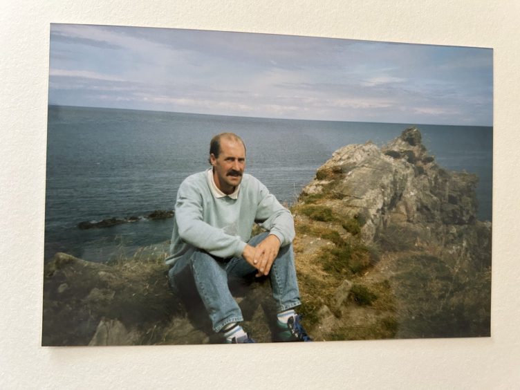 Family photo of Roderick Nicolson seated next to rocks by the sea