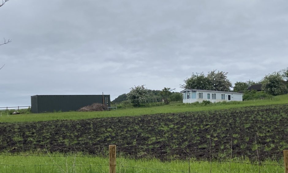 The caravan and one of the containers in the field