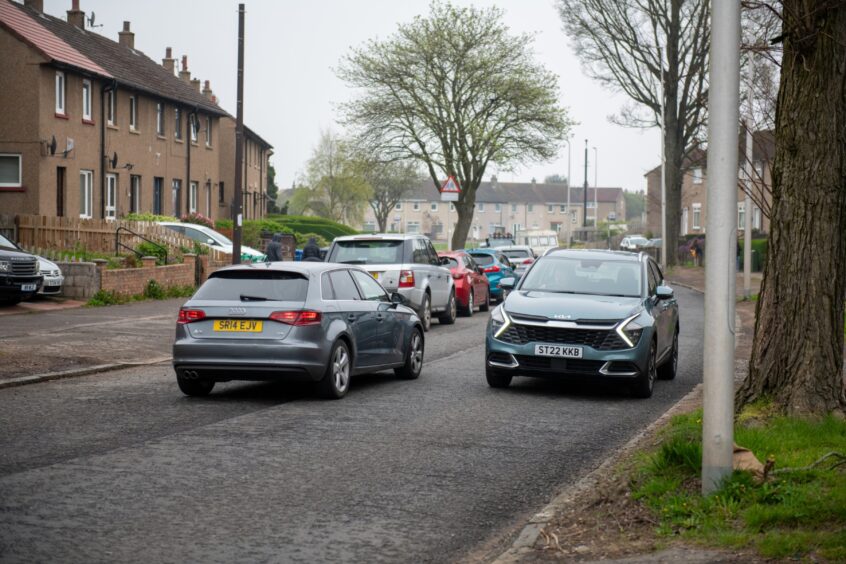 Cars parked along Balunie Drive. 