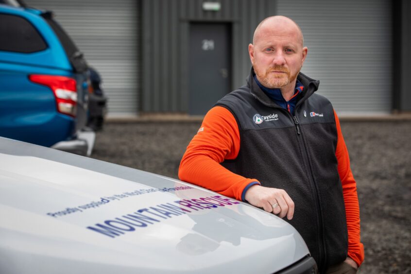 Paul Russell leaning on bonnet of vehicle