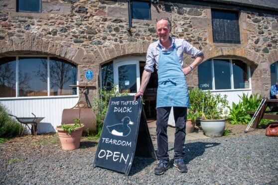 Tim Hardie in blue apron standing next to Tufted Duck sandwich board