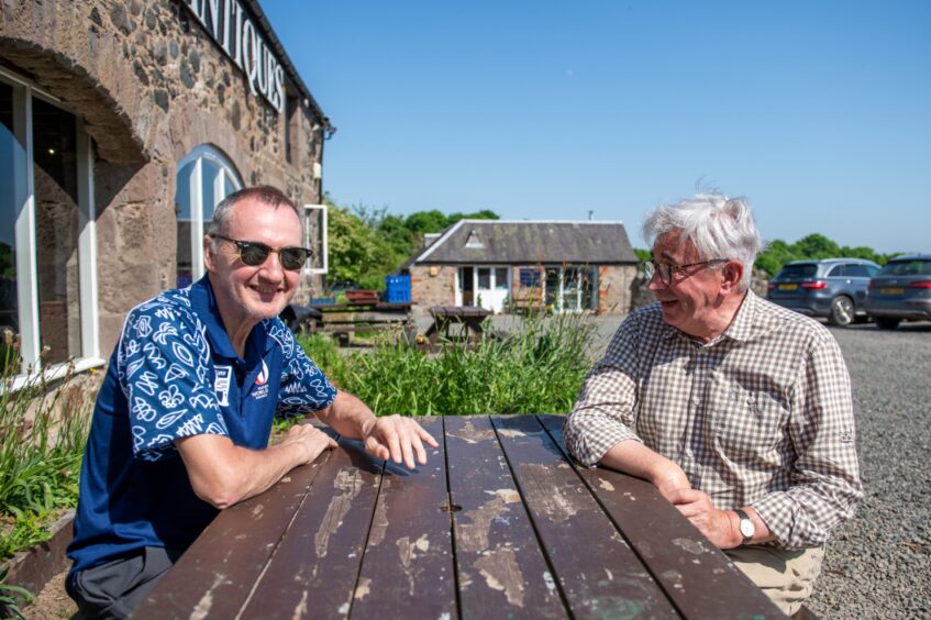 John MacPhee and Jim Buchan seated at picnic table outside Tufted Duck tearoom