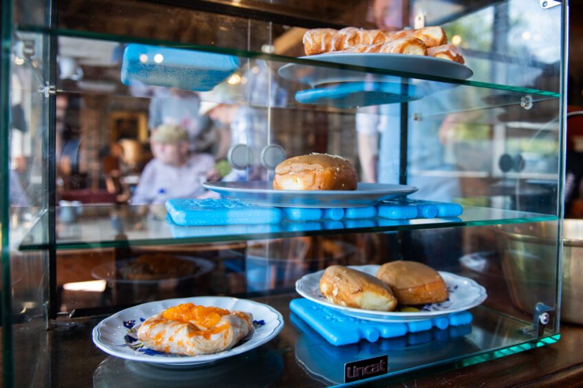 Plates with donuts and pastries inside glass display case