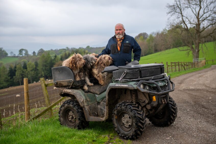 Douglas McCartney standing next to quad bike with dogs in drivers seat