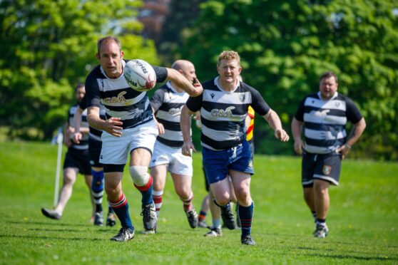 Perthshire rugby club players chasing rugby ball on North Inch, Perth