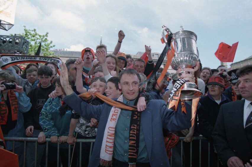 Maurice Malpas holds the Scottish Cup as he celebrates with United supporters. 