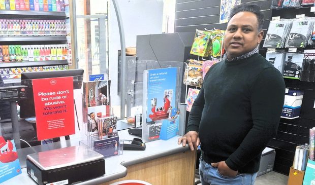 Aberfeldy post master Seenithamby Sujeevan standing next to his post office counter