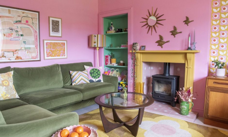 The living room, with pink walls and a green sofa