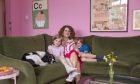 Heather Craig and her two children sit on the couch in the Pink House in Crossford, Fife