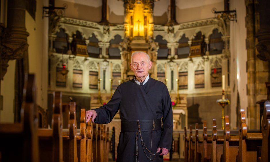 Father James MacManus of St Mary's Monastery, Kinnoull Hill, in between the pews of his church