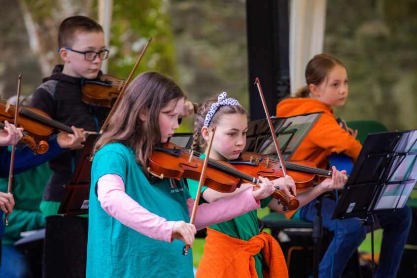 Young musicians from the Dunkeld and Birnam Traditional Youth Music Group playing fiddles.