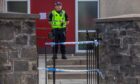 Police officer stands guard at St Mary Magdalene's Church in Perth following sudden death of man.