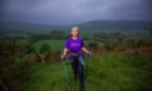 Dee Thomas with walking poles halfway up hill near Comrie in mist