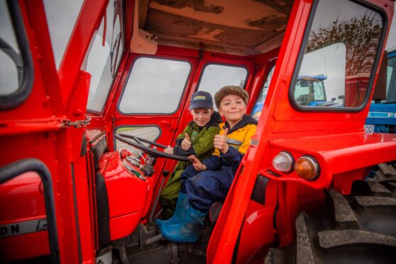 Six-year-olds David Brown (left) and Joe Ritchie have a seat in one of the machines. Image: Steve MacDougall/DC Thomson