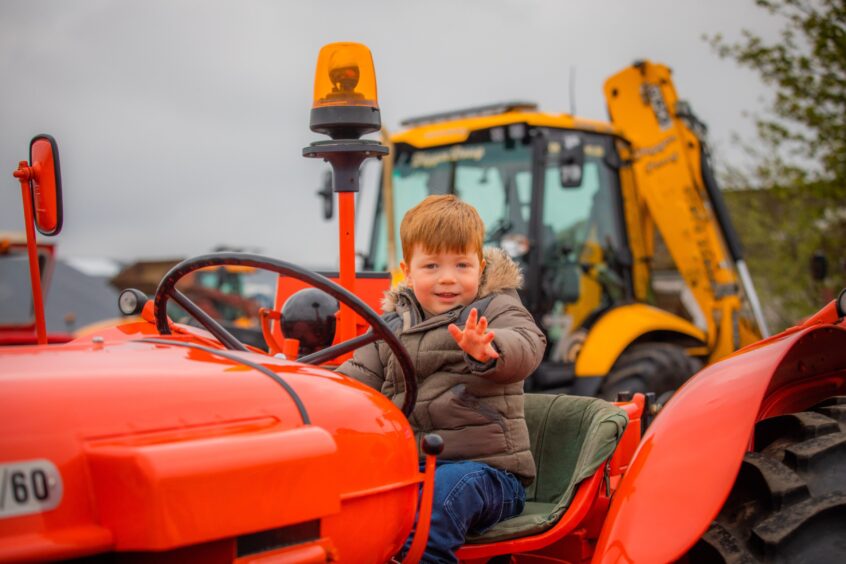Young boy on vintage tractor in Angus charity run.