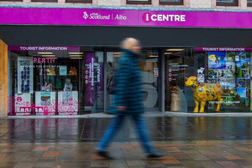 Person walking past VisitScotland shop in Perth city centre
