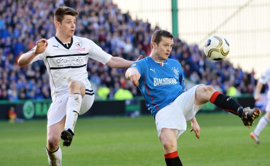 Dougie Hill challenges Rangers' Jon Daly during Raith Rovers' Ramsdens Cup triumph in 2014.