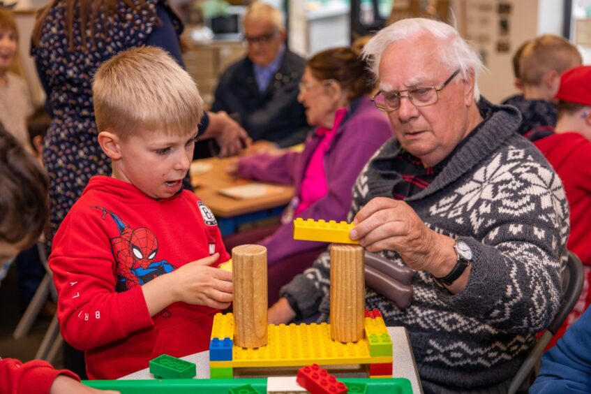 Older man and little boy building lego model in Crieff nursery class